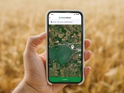 person holding a cell phone in a field using the Cropwise Sustainability app