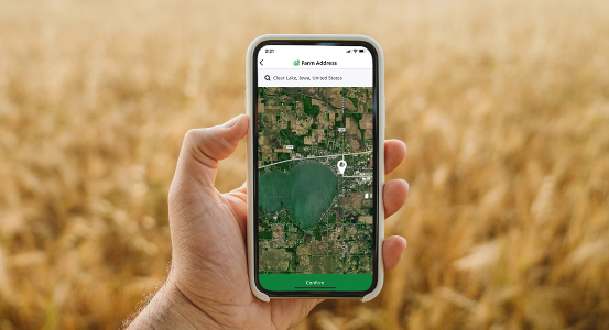 person holding a cell phone in a field using the Cropwise Sustainability app